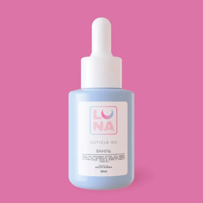 Light blue Luna cuticle oil bottle with dropper on a pink background, nail care product.