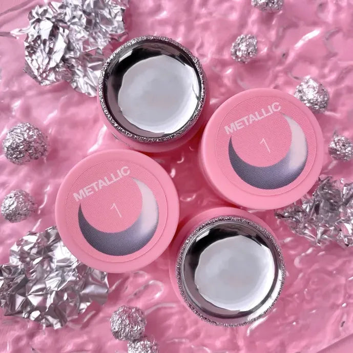 Metallic gel jars for nail art on textured pink background with silver foil accents