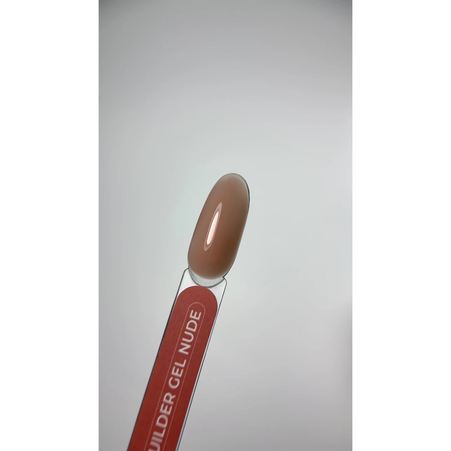 Nude builder gel nail polish color sample on clear swatch stick