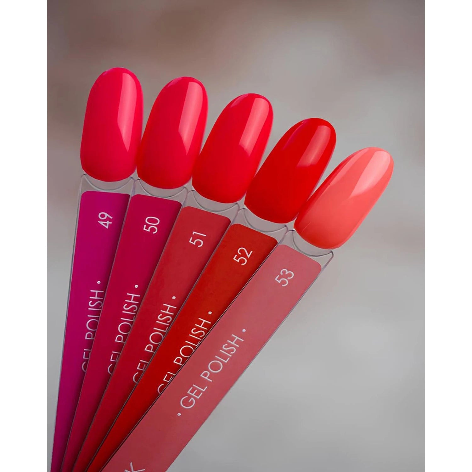 Five bright red and pink gel nail polish swatches for manicure