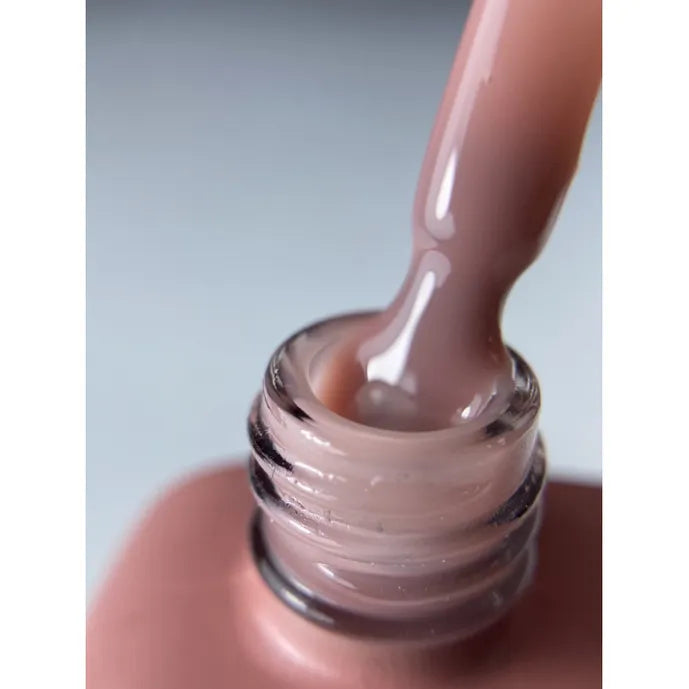 Close-up of a mauve pink gel nail polish bottle with brush and glossy texture