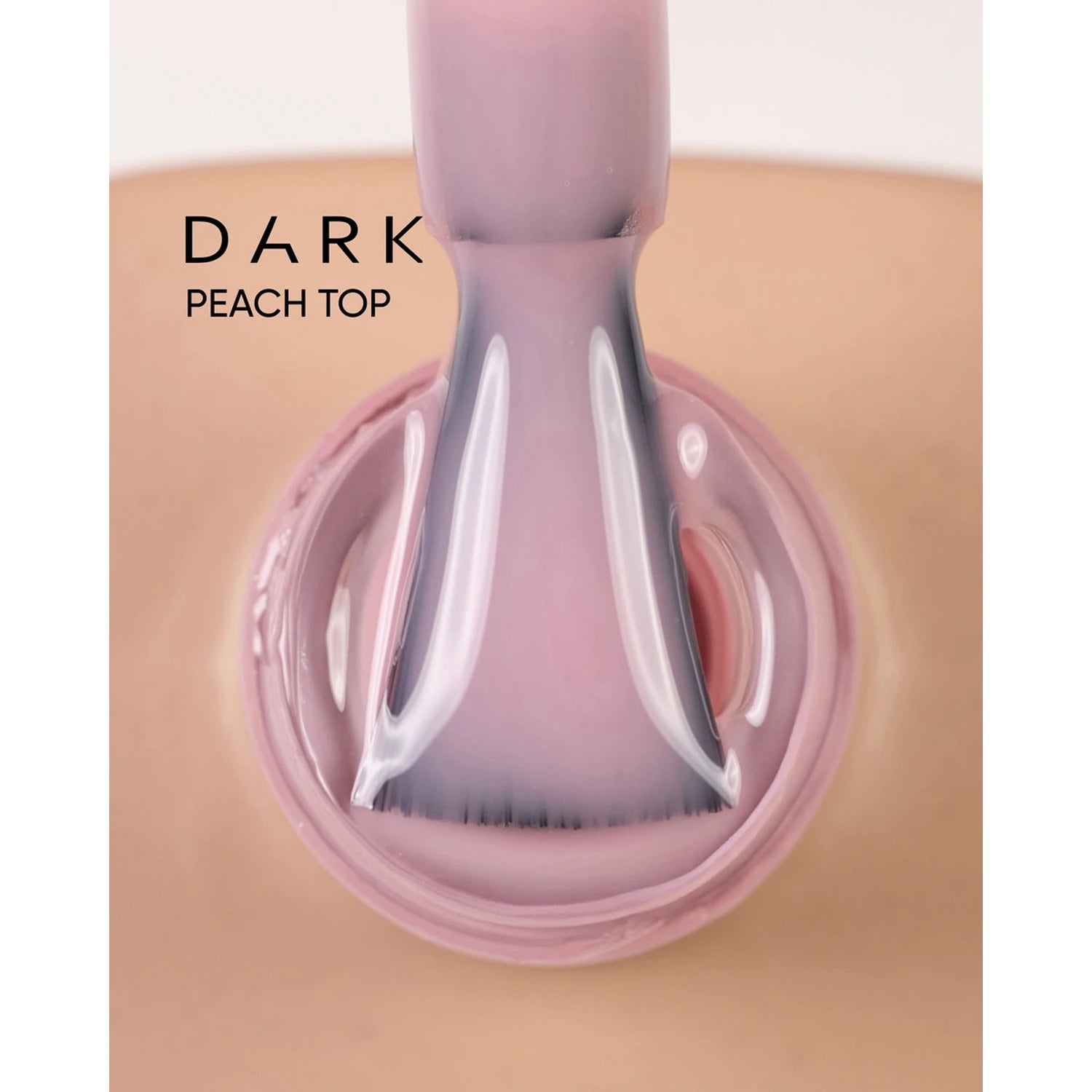 Brush applying dark peach top gel polish to fingernail, glossy manicure finish