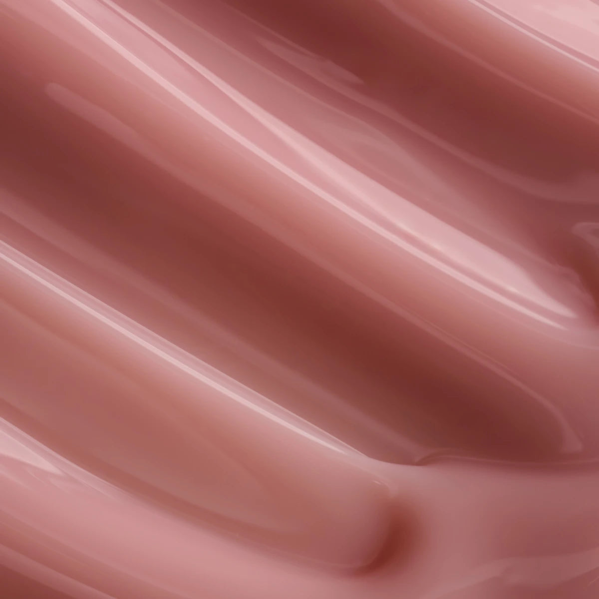 Close-up of glossy nude pink gel polish texture for nail art and manicure