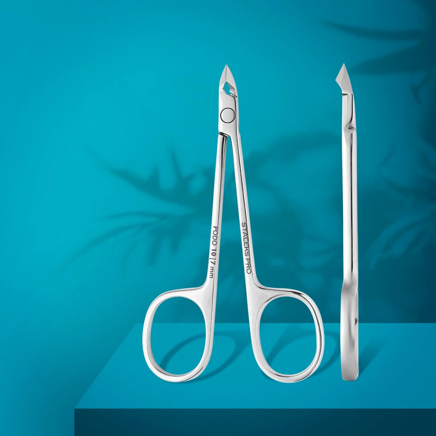 Stainless steel nail cuticle nippers for manicure and pedicure on blue background