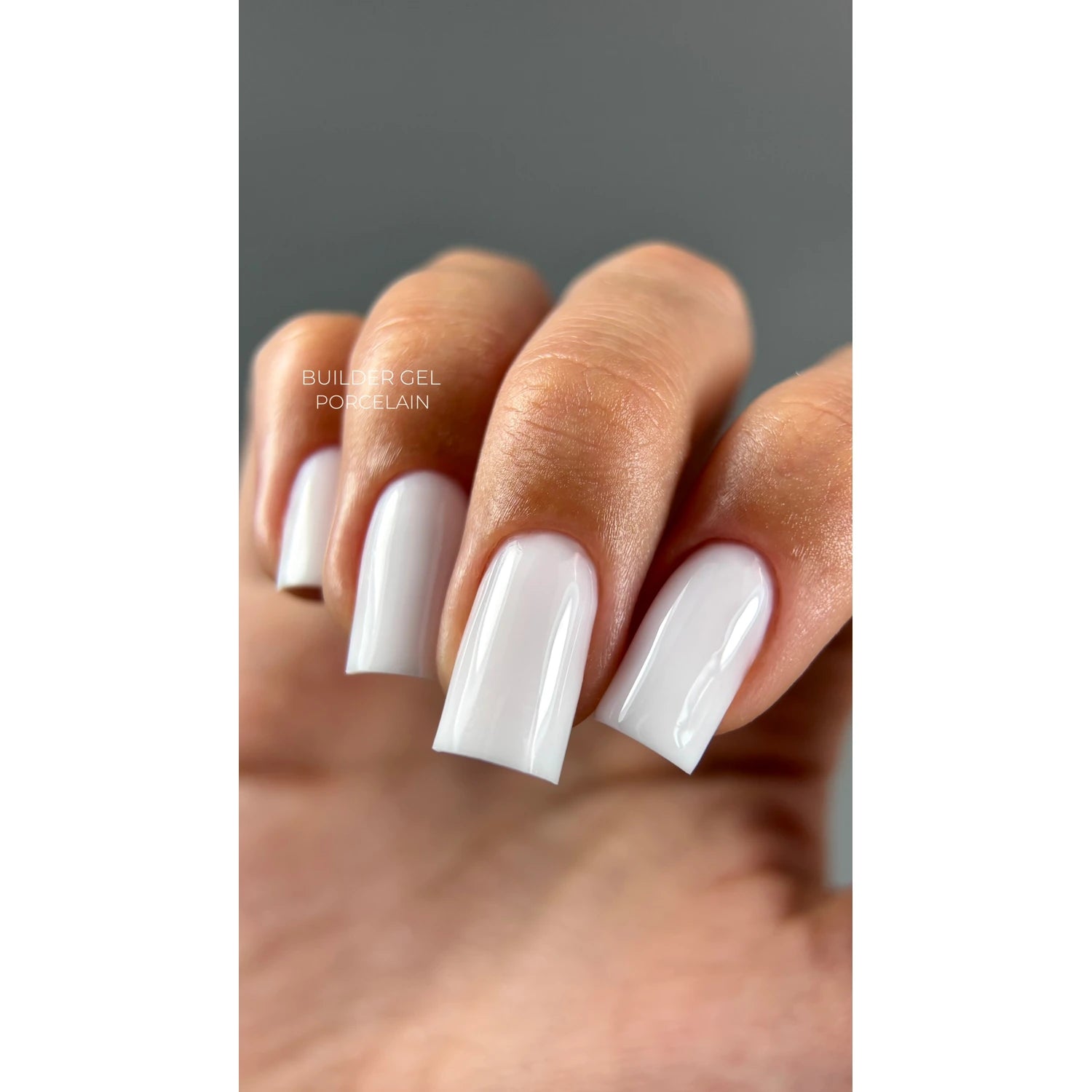 Hand with glossy square-shaped porcelain builder gel nails, professional manicure