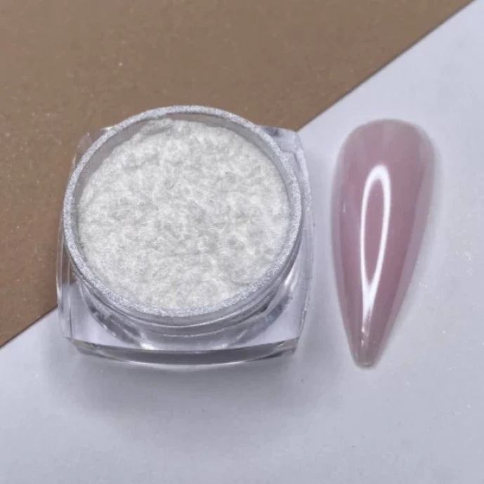 White nail art powder in a clear jar beside a glossy nude acrylic nail sample