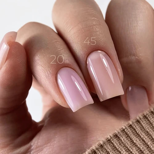 Close-up of hand with glossy nude pink gel manicure, showing natural nail extension effect.