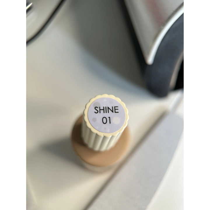 SHINE 01 UV gel nail polish bottle with ridged cap, next to a nail file