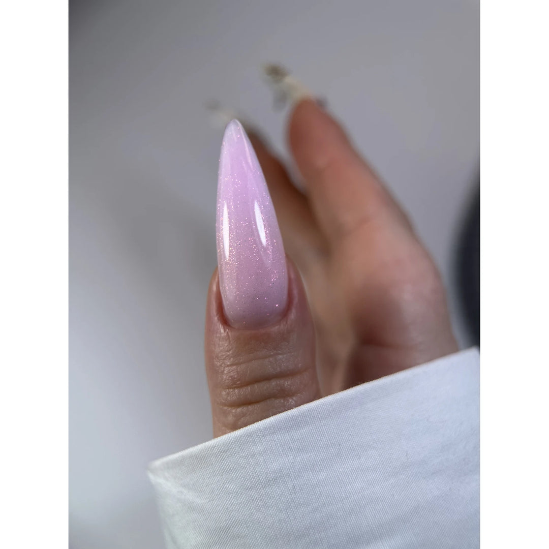 Long stiletto nail with glossy light pink ombre and subtle shimmer manicure
