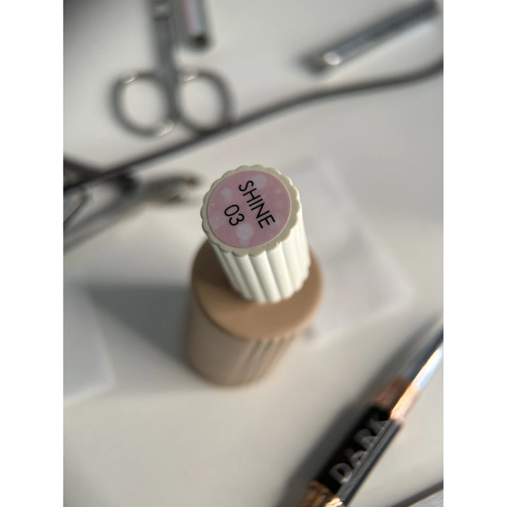 SHINE 03 UV gel polish bottle on manicure table with nail tools nearby