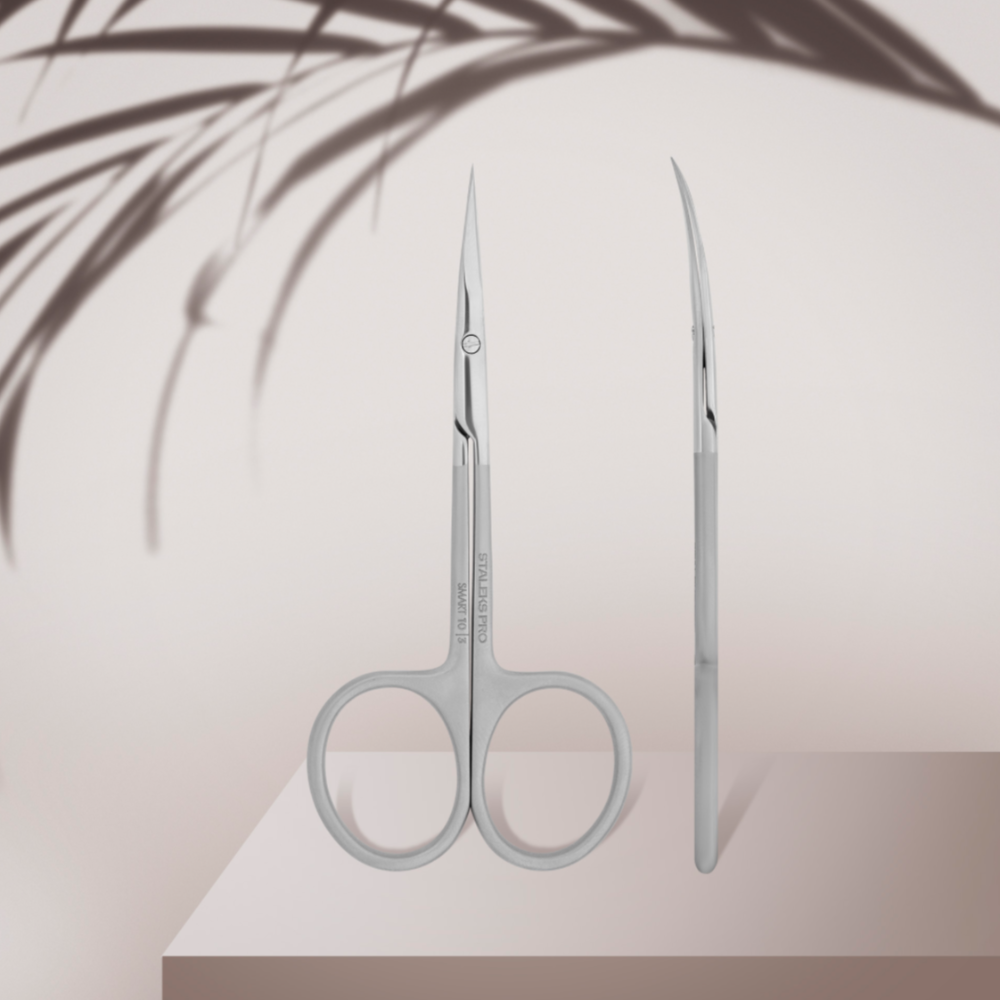 Stainless steel curved manicure scissors for nail and cuticle care on neutral background