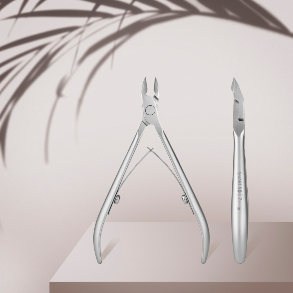Stainless steel cuticle nipper and pusher for manicure, displayed on neutral background