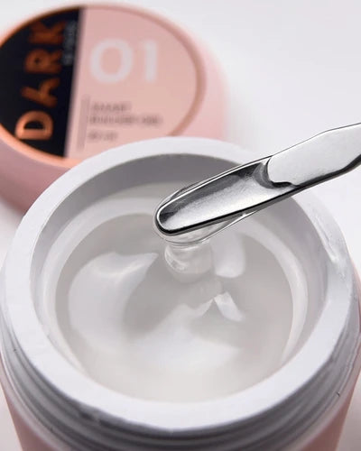 Open jar of clear builder gel for nails with metal spatula, manicure accessory