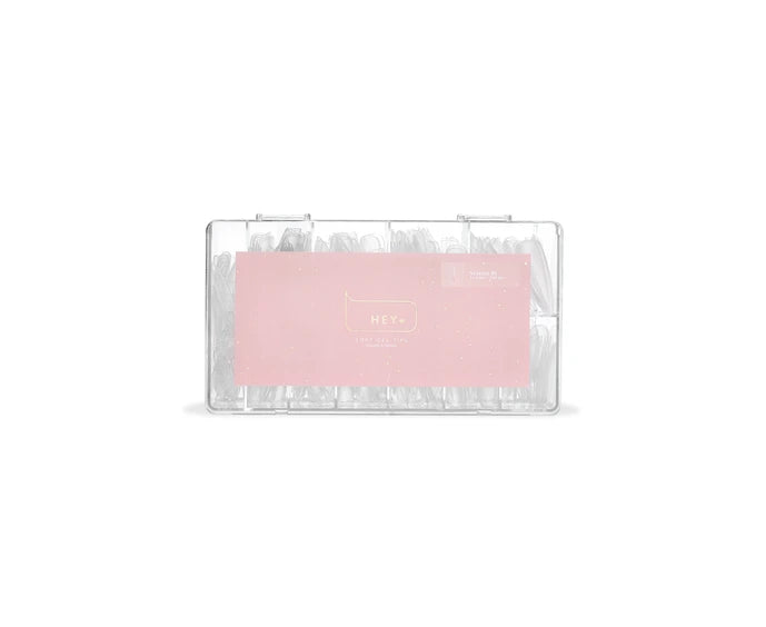 Clear stiletto nail tips in plastic case for professional manicure and nail extensions