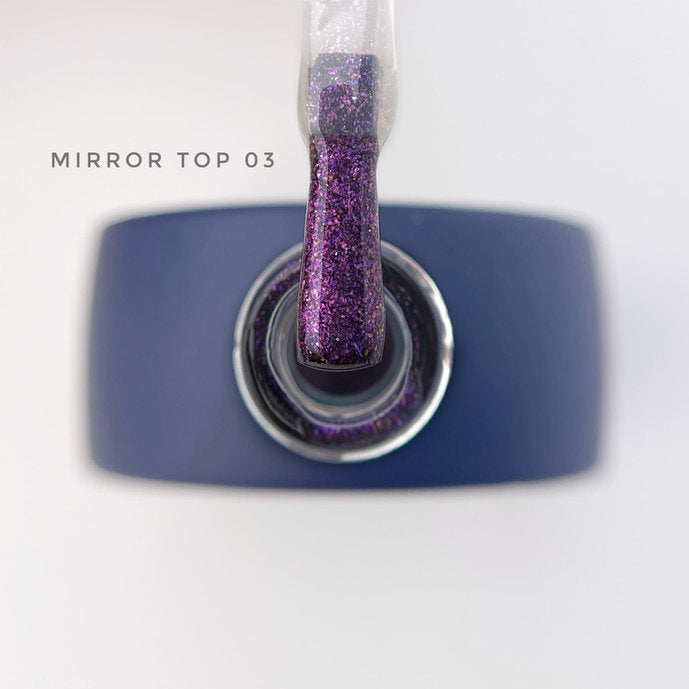 Purple glitter mirror top gel polish with applicator above blue bottle
