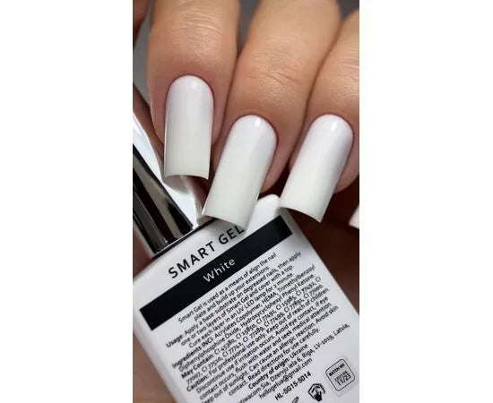 Close-up of manicured hand with long square white gel nails holding white Smart Gel polish bottle.